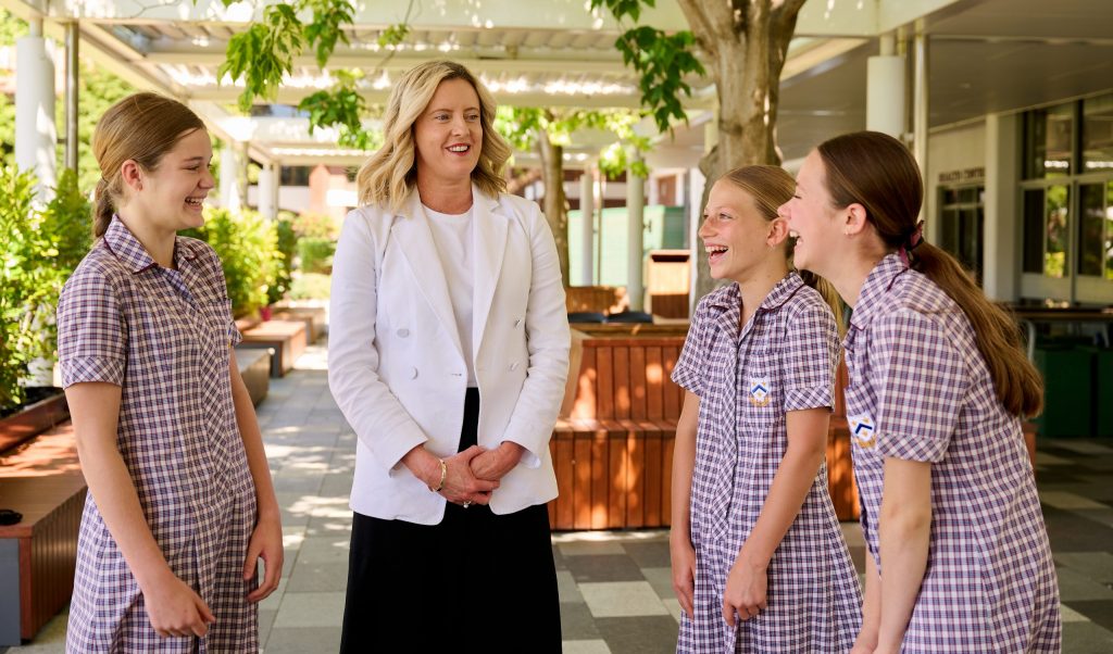 A woman in a white coat conversing with four girls at St Mary's Anglican Girls School, a boarding school in Perth.