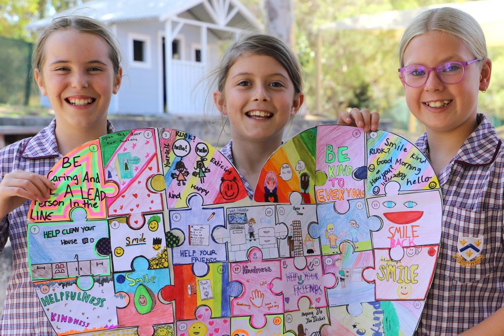 Three girls holding up heart-shaped puzzle at St Mary's Girl's boarding School Early Learning Centre, fostering potential.