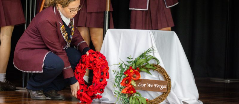Student laying a wreath