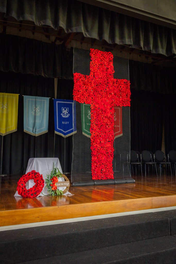 A large cross made from red poppies on the Dannatt Hall stage